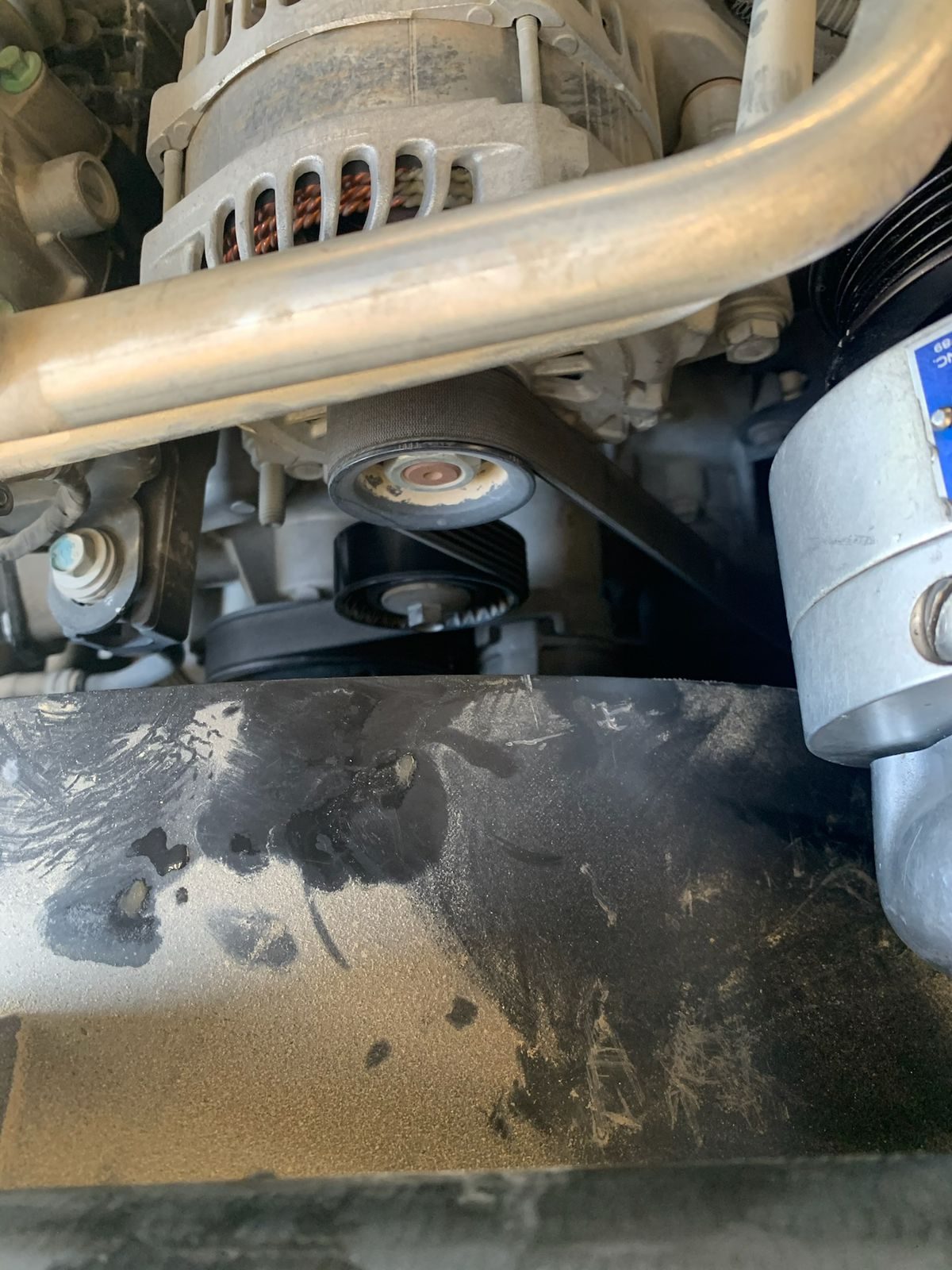 Close up of the alternator and tensioner pulley. Years of dirt and grease, fresh skinned knuckle territory.