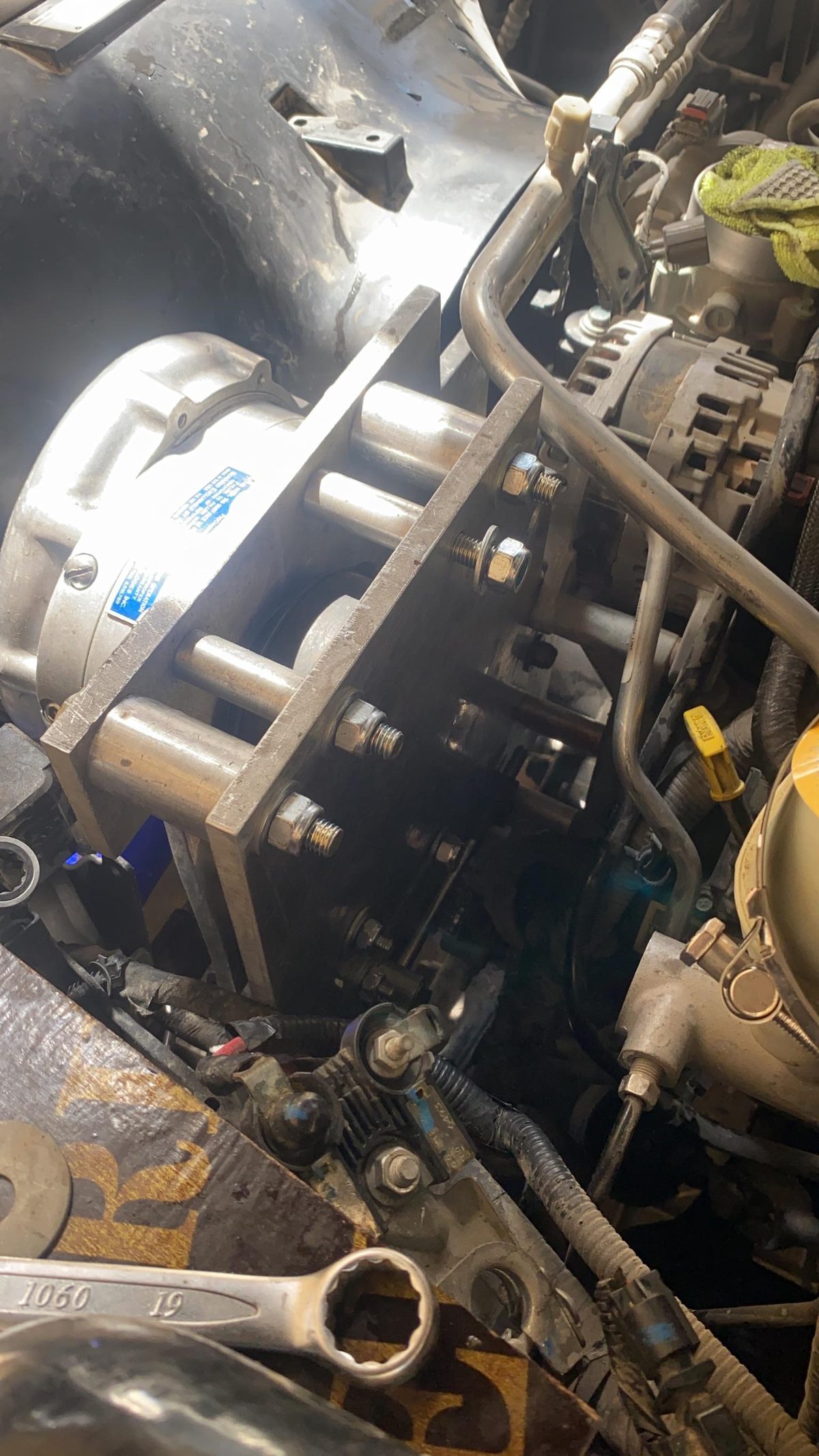 Aluminum bracket installed in the bay with the threaded bolts holding the ProCharger from below.